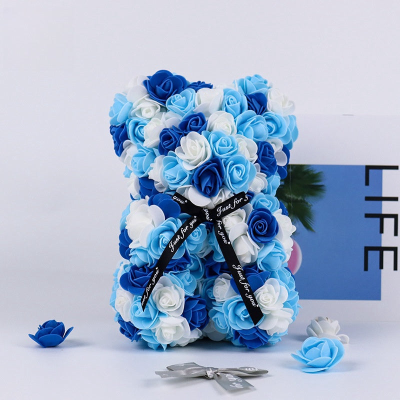 An elegant rose teddy bear composed of artificial flowers, making it a perfect addition to wedding decor or as a thoughtful gift.