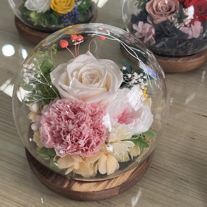 Artificial flower arrangement in glass dome.