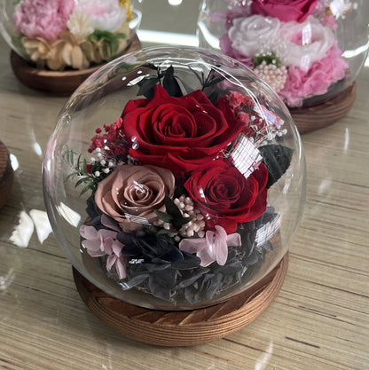 Artificial preserved rose in a glass dome.